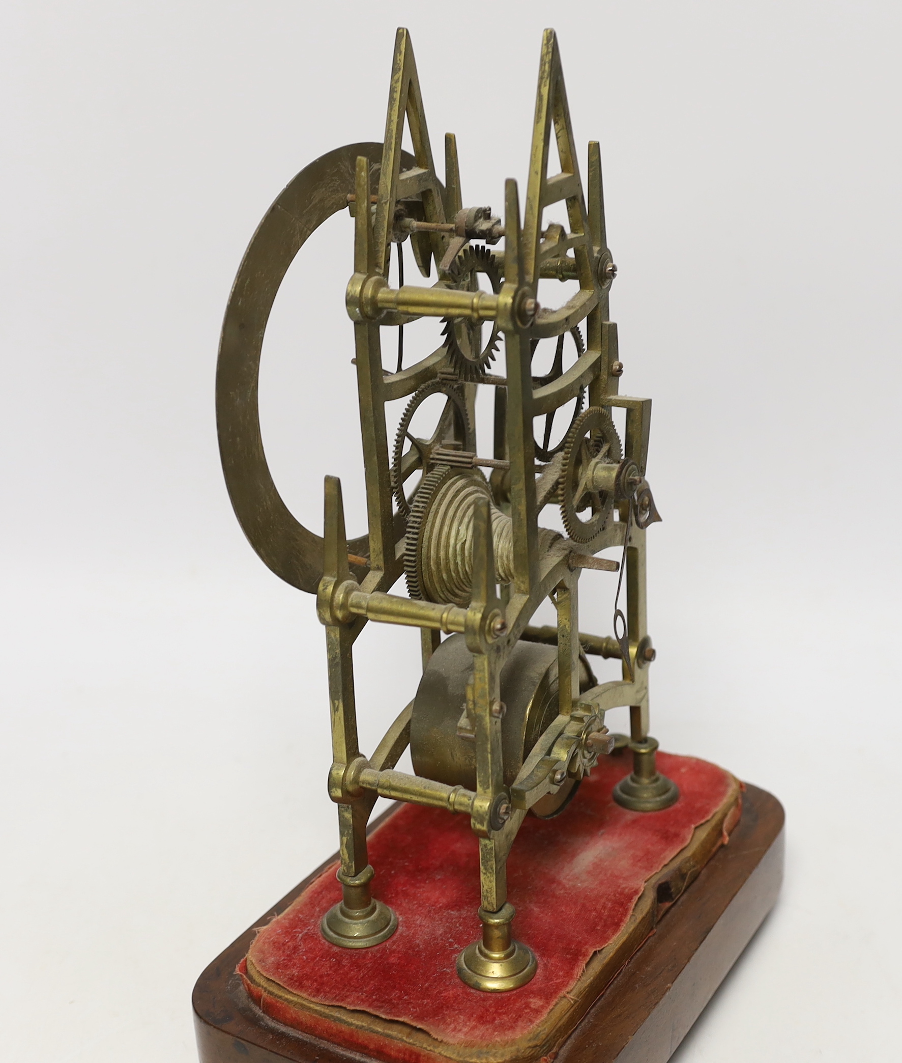 A skeleton clock with Roman numeral dial, on wooden base, 33cm high